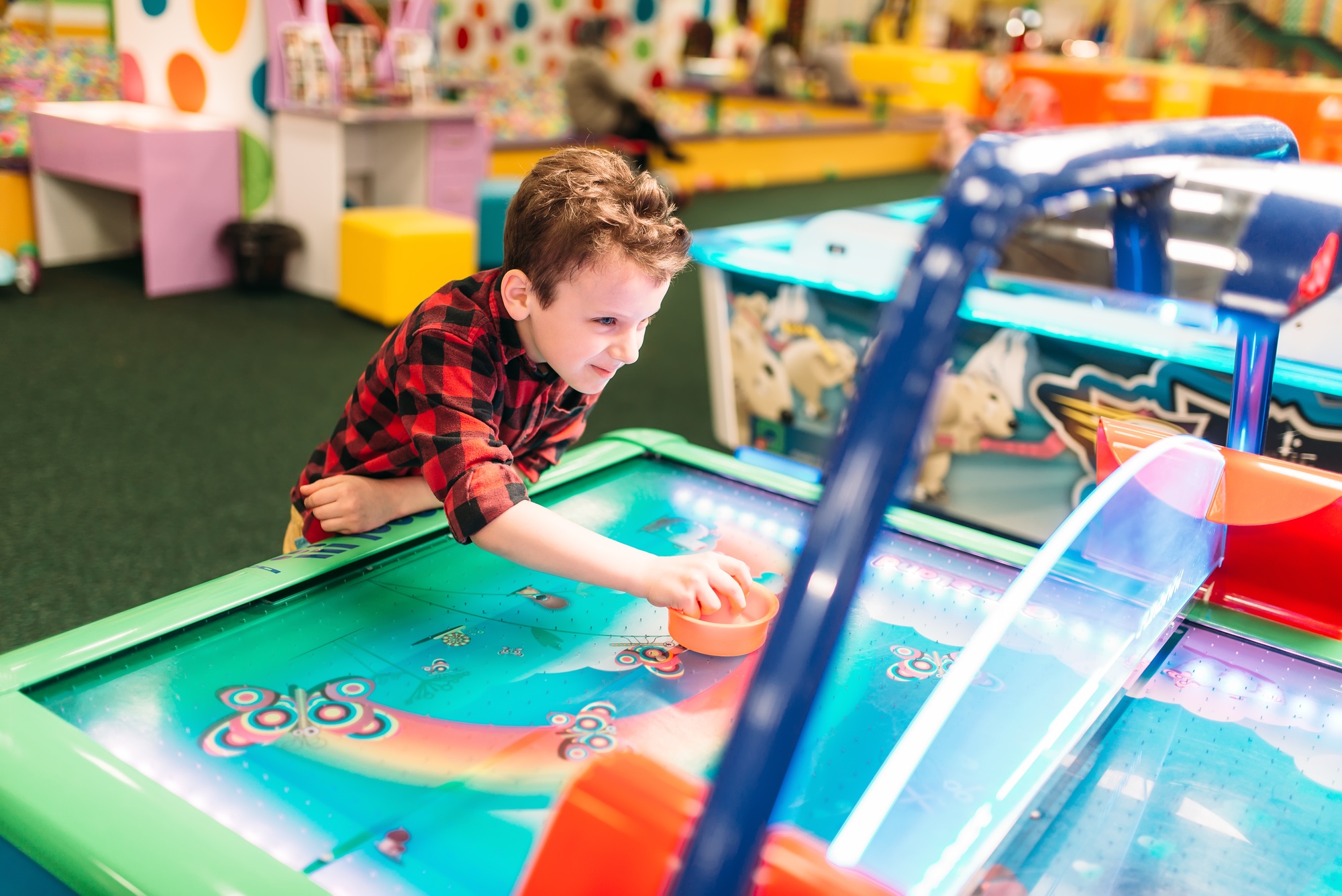 Active boy plays air hockey, entertainment center